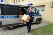 Umundurowany policjant niosący pudełko