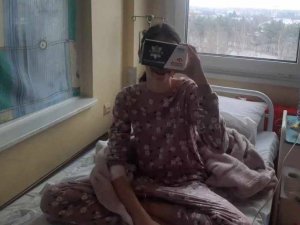 Dziecko siedzące na szpitalnym łóżku z okularami vr przy twarzy