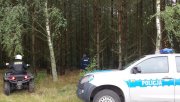 Policyjny radiowóz oraz quad na tle lasu