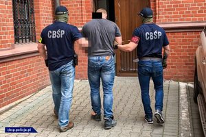 policjanci CBŚP prowadzą osoby zatrzymane