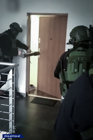 policjanci wyważają drzwi od mieszkania