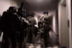 Policyjni kontrterroryści stojący na korytarzu.
