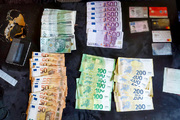 Liczne banknoty o nominale 50, 100, 200 oraz 500 EUR. Banknoty o nominale 100 PLN oraz karty kredytowe leżące na stole.