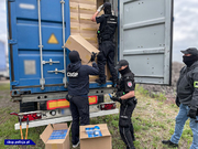 Policjanci i funkcjonariusze KAS rozładowują kontenery z papierosami