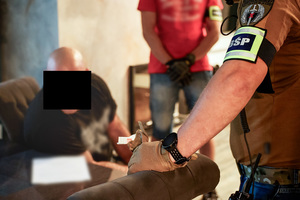 policjanci w trakcie działań i przejęte pieniądze