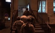 Na zdjęciu pora nocna - policyjni kontrterroryści prowadzą zatrzymanego mężczyznę po schodach, wprowadzając go do Komendy Powiatowej Policji w Przeworsku