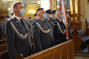 Komendant Wojewódzki Policji w Rzeszowie wraz z zastępcami, stojący w ławkach kościelnych.