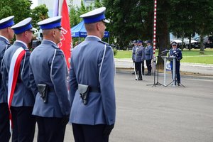 Komendant Wojewódzki Policji w Rzeszowie insp. Dariusz Matusiak przy mównicy. Na pierwszym planie po lewej poczet sztandarowy.