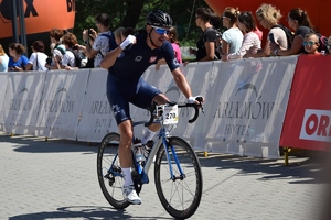 Zmagania kolarzy na trasie podczas wyścigu, kolarz przekraczający linię maty wyścigu Tour de Pologne
