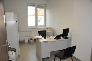 pomieszczenie biurowe, biurko, komputer z monitorem i metalowe szafy
