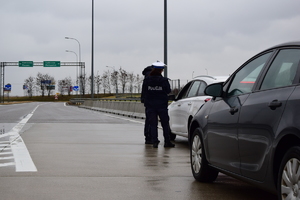 policjanci podczas kontroli drogowej, dwa samochody stojące na drodze