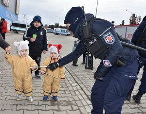 Policjantka wręcza dzieciom odblaski