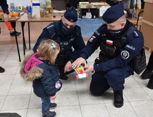 Policjanci dają zabawkę małej dziewczynce