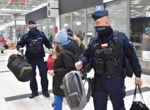 Policjanci pomagają przenosić bagaże