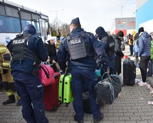 Policjanci pomagają przy wnoszeniu bagaży