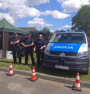 troje policjantów stojących obok radiowozu w czasie pikniku w Jedliczu