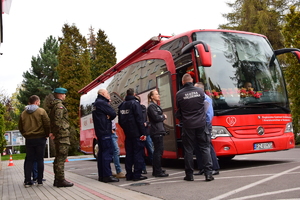 policjanci oraz inni funkcjonariusze stojący przed autobusem do poboru krwi