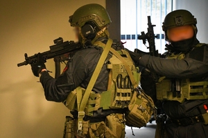 Policjanci podczas ćwiczeń w jednej z firm w Jasionce. Policyjni kontrterroryści z bronią przeszukują pomieszczenia biurowe.