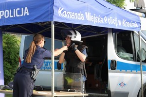Policjanci podczas festyny podczas prezentacji wyposażenia na stoisku ekspozycyjnym