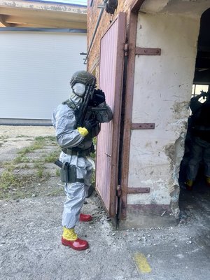 umundurowany kontrterrorysta z bronią wchodzi do budynku