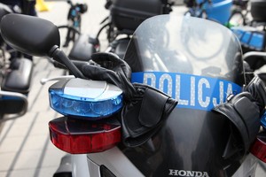 policyjny motocykl na którym leżą skórzane rękawiczki motocyklowe