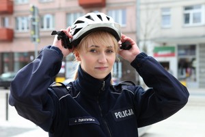 policjantka zakłada kask rowerowy