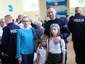 na zdjęciu nowo przyjęty policjant z rodziną po uroczystej zbiórce