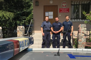 Policjanci z Komisariatu Policji w Barczewie stojący przed budynkiem a za radiowozem