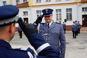 Policjant odbierający akt mianowania od nadinsp. Tomasza Klimka