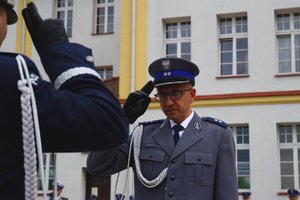 Policjant odbierający akt mianowania od nadinsp. Tomasza Klimka