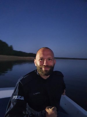 Policjant podczas zajęć praktycznych w łodzi na jeziorze