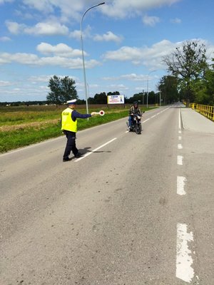 Policjant podczas kontroli drogowej motocyklisty w Kętrzynie
