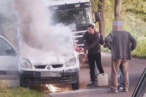 st. asp. Piotr Zalewski gaszący auto na drodze