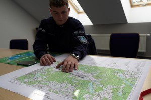 Policjant podczas szkolenia obserwuje mapę na biurku