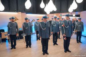 Zdjęcie przedstawia stojących w szyku członków policyjnej orkiestry