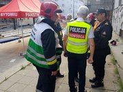 dowódca akcji policyjnej - mł. insp. Mariusz Krzystyniak rozmawia na miejscu eksplozji z przedstawicielami straży pożarnej