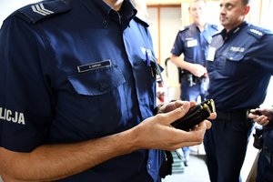 policjant trzymający w dłoniach dwa załadowane magazynki