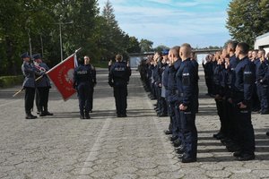 Zdjęcie kolorowe, przedstawiające policjantów z pocztem sztandarowym.