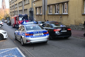 Zdjęcie przedstawiające samochody służb ratowniczych na tle Polikliniki MSWiA