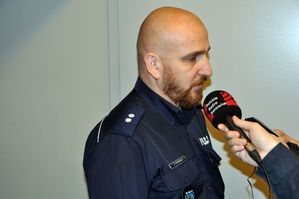 Na zdjęciu policjant udzielający wywiadu stacji radiowej
