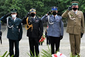 Przedstawiciele służb mundurowych, w tym Zastępca Komendanta Wojewódzkiego Policji oddają honor przed Pomnikiem Powstańców Śląskich