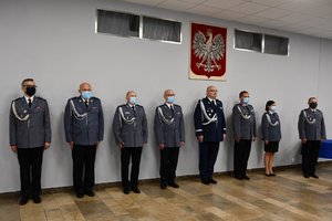Kierownictwo śląskiej Policji stojące pod Godłem wiszącym na ścianie