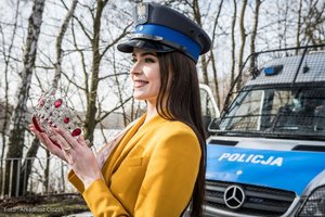 Zdjęcie kolorowe. Widoczna Miss Polski 2020 trzymająca w dłoniach koronę na tle radiowozu. Autor zdjęcia: Arkadiusz Ciozak