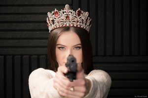 Zdjęcie kolorowe. Widoczna Miss Polski 2020 trzymająca w dłoniach pistolet. Autor zdjęcia: Michał Piątek