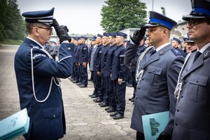 Komendant  Wojewódzki Policji w Katowicach inspektor Roman Rabsztyn wręcza akt mianowania i gratuluje funkcjonariuszowi.