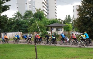 Kolorowa fotografia przedstawia rowerzystów jadących drogą.