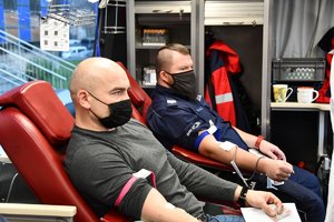 Mężczyźni oddający krwew w ambulansie poboru krwi.