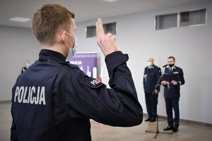 Umundurowany, nowo przyjęty policjant podczas ślubowania oraz Komendant Wojewódzki Policji w Katowicach.