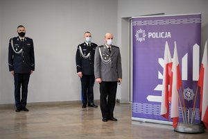 Policjanci z Wydziału Gabinet Komendanta Wojewódzkiego Policji z Naczelnikiem tego wydziału. Widoczny również baner z napisem Policja.