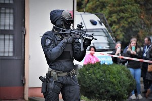 Zdjęcie. Widoczny umundurowany policjant z bronią maszynową